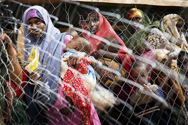 Сомалийские женщины и дети в ожидании раздачи пайков в Центре питания в Дадаабе, Кения. Дадааба представляет собой крупнейший в Африке лагерь беженцев, где проживают более 250 тысяч людей, бежавших из Сомали из-за продолжающегося военного конфликта.
