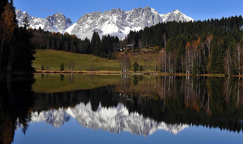 Заснеженные Альпы в горнолыжном австрийском курорте Китцбюэль отражаются в одноименном озере