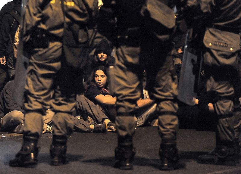 Полиция по охране общественного порядка стоит перед группой молодежи во время демонстрации в Афинах. Тринадцать полицейских были ранены в ходе столкновений во время акций протеста, которая прошла в ознаменование годовщины студенческого восстания 1973, сообщают официальные представители греческой полиции.