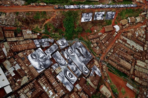 JR взял за основу для своего творения – 2000 квадратных метров крыш домов плотно расположенных между собой в Кибера. Женщины – героини в трущобах Кибера – Кения. Январь 2009 года.  