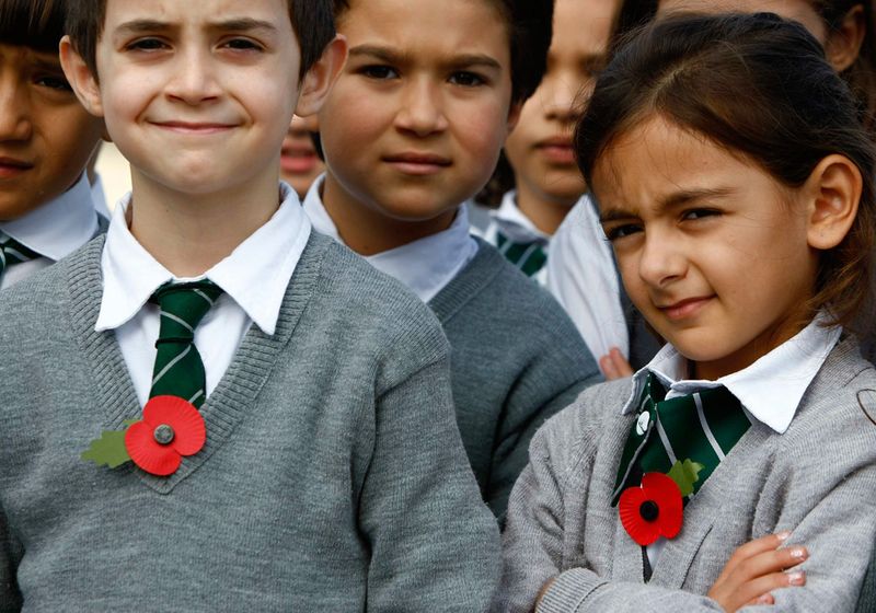 Школьники со значками в виде маков участвуют в церемонии в честь Дня Примирения в Валетте, Мальта, 11 ноября.