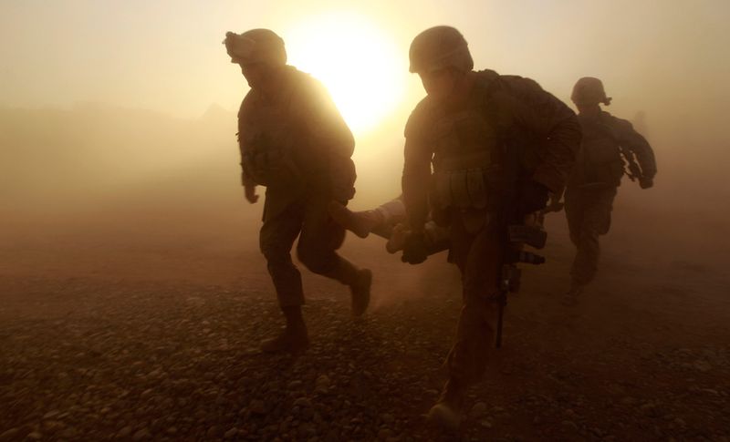 Американские солдаты несут раненого товарища в вертолет в провинции Гильменд