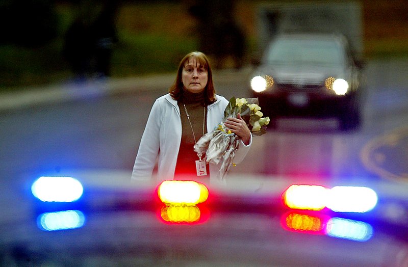 Cотрудница муниципалитета принесла цветы к штаб-квартире полиции в Лейквуде, штат Вашингтон, после того как в воскресенье в кофейне боевиком были убиты четыре сотрудника полиции. В Сиэтле в понедельник команда SWAT взяла штурмом один из домов, где, как полагали, находился подозреваемый. Но попытка не удалась, и стрелок все еще остается на свободе