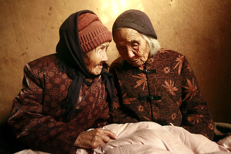 Близнецы Цао Сяоцяо, слева, и Цао Дацяо у себя дома в Вэйфан, в китайской провинции Шаньдун. Им 104 года, и согласно Книге рекордов Гиннеса, они являются самыми старыми ныне живущими близнецами